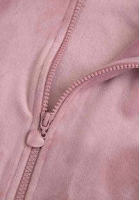 Bladoróżowa polarowa kurtka z zamkiem błyskawicznym i serduszkowym zaczepem. Miękka tekstura z subtelnymi odcieniami kolorów.