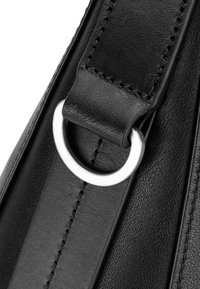 Cinturino per borsa in pelle nera con texture liscia, caratterizzato da un anello metallico argentato e cuciture precise lungo i bordi.