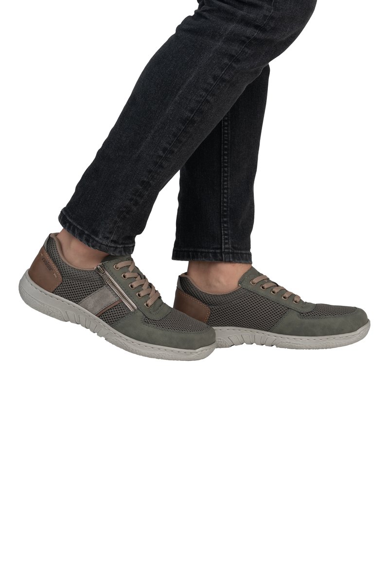 Green and grey mesh sneakers with a patterned upper, tan accents, and a white sole. Features laces and a side zipper for easy access.