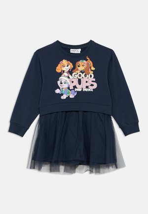 Marineblå kjole med en sweatshirt-topp og tyl skjørt. Har tegneseriehundkarakterer og teksten «Good Pups Paw Patrol» i rosa og hvitt.