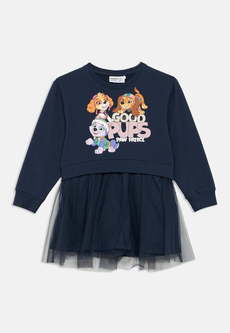 Tumši zila kleita ar džemperveida augšdaļu un tilla svārkiem. Uz tā attēloti karikatūru suņu tēli un teksts "Good Pups Paw Patrol" rozā un baltā krāsā.