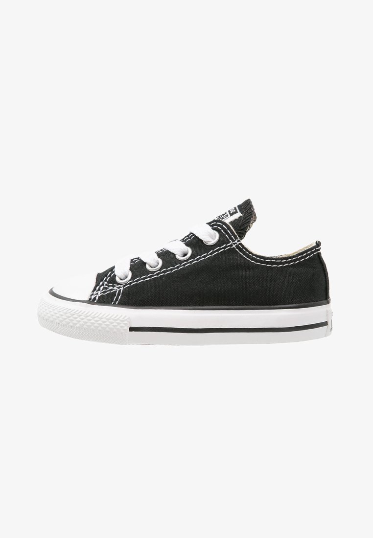 Svart kanvas sneakers med hvit gummisåle og tåhette, med hvite lisser og kontraststing. Lavskåret design med svarte aksentstriper.