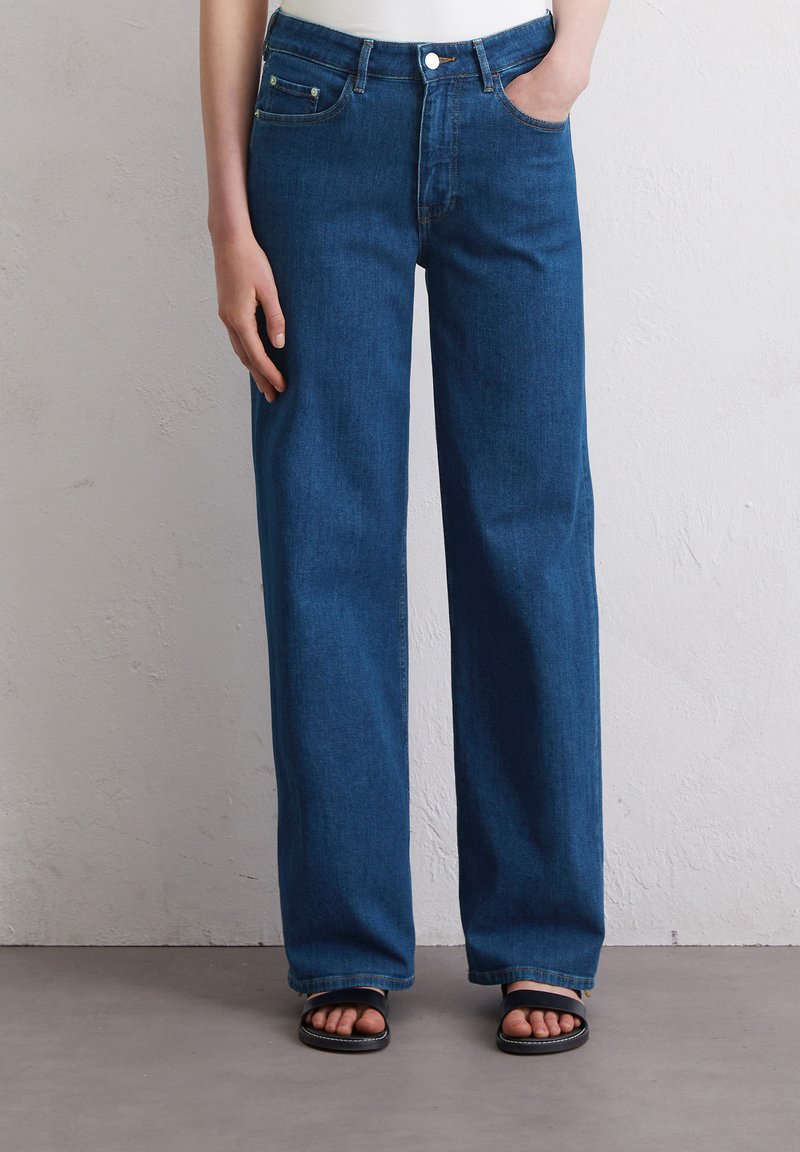 Spijkerbroek van blauw denim met wijde pijpen en een klassieke vijf-pocket ontwerp, voorzien van een ritssluiting en een middelhoge taille. Soepele textuur en schone naden.