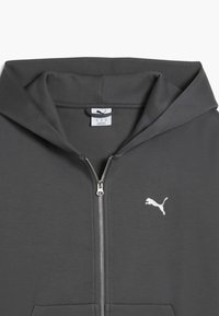 Donkergrijze zip-up hoodie met een witte Puma-logo. Kenmerkt zich door een grote capuchon, een gladde textuur en een metalen ritssluiting aan de voorkant.