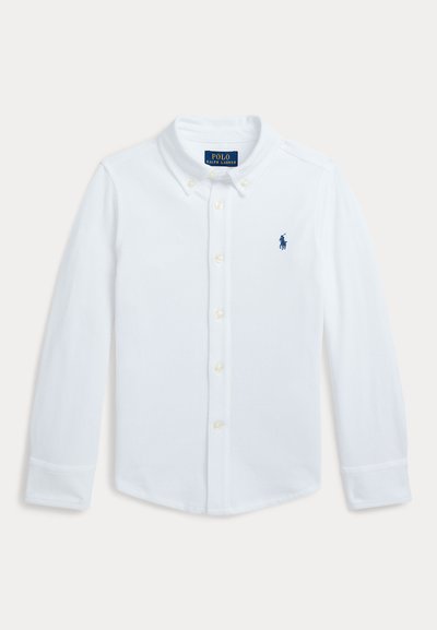 Cămașă albă cu mâneci lungi și nasturi, realizată din bumbac. Prezintă un guler clasic și un logo bleumarin pe partea stângă a pieptului. Nasturii sunt de culoare crem.