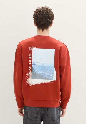 Rode sweatshirt met een zachte textuur, voorzien van een grafisch ontwerp van een kustlijn, tekstaccenten en een ronde hals.