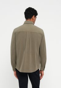 Olijfgroene lange mouw shirt met een gladde textuur, knoopmanchetten, subtiele verticale strepen en een rechte zoom. Achteraanzicht weergegeven.