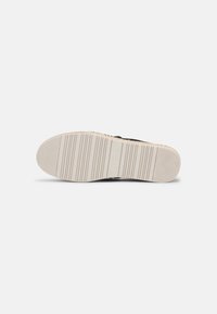 Semelle de chaussure avec une bande de roulement en caoutchouc beige présentant des rainures horizontales, un talon texturé et le logo "s.Oliver" au centre.
