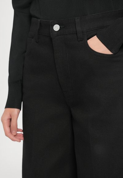 Pantaloni negri cu o textură netedă, având un buzunar frontal, un talie rezistentă și un detaliu cu buton argintiu.