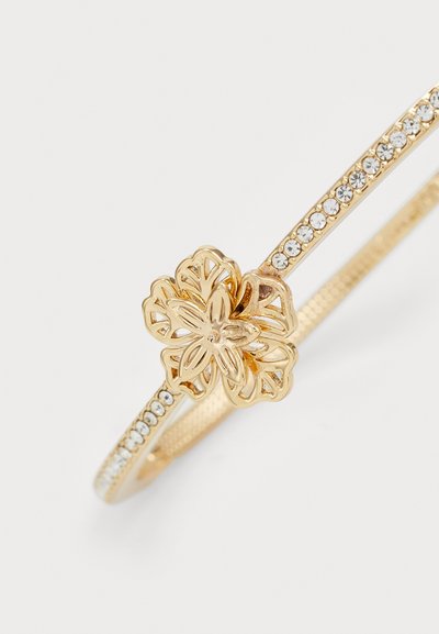 Kuldmetallist käevõru, millel on lilleline disain lõigatud detailidega ja rida selgeid rhinestone'e riba ääres. Sile tekstuur, peen kuju.