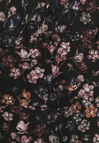 Black fabric with a floral pattern in pink, purple, and orange hues; features black buttons and subtle texture with seams visible.