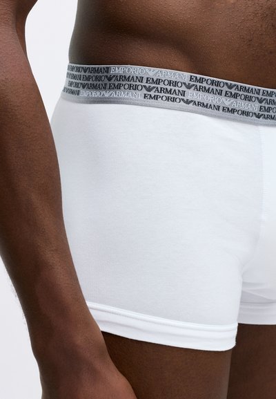 Fehér pamut boxer alsónemű, szürke elasztikus derékpánttal, fekete "Armani Emporio" márkázással, sima textúrával és testhezálló dizájnnal.