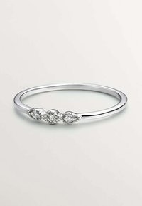 Anillo de plata con tres piedras preciosas claras en forma de pera, engastadas en acentos decorativos. Superficie lisa y pulida con una delgada banda circular.