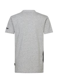 Camiseta gris de manga corta hecha de algodón. Presenta un panel lateral negro y un branding minimalista en la manga izquierda. Corte casual.