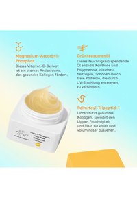 Lip mask in a white, square jar with a smooth, yellow-gold product inside. Bright yellow lid beside jar on a gradient background.