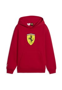Sweat à capuche rouge en mélange de coton, avec un logo central jaune en forme de bouclier portant un cheval cabré noir, poche avant, et poignets côtelés.