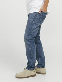 Tumedates denim püksid, slim fit, klassikalise viie tasku disainiga. Kandmiseks beežid nabuki nahast kingad, et saavutada mugav välimus.
