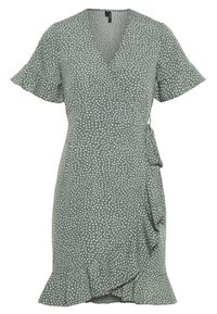 Zelené šaty s krátkým rukávem, bílými puntíky, volánkovým lemem a páskem na zavázání v pase. Vyrobeno z lehké, strukturované tkaniny.