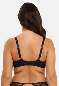 Soutien-gorge noir en tissu lisse, avec bretelles réglables et fermeture à crochets au dos. Présente un design simple et une silhouette discrète.