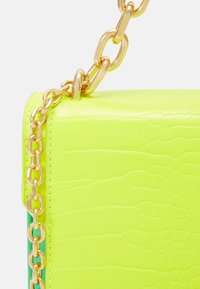 Neon green croc-embossed handbag with a gold chain strap and accent. Rectangular shape with smooth texture and glossy finish.