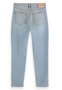 Jean bleu clair à jambe droite vu de dos, avec deux poches arrière et une étiquette beige sur la ceinture.
