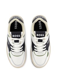 Baskets avec une tige en toile blanche, des accents en cuir noir, des détails verts et une semelle en caoutchouc beige. Comprend une languette et des lacets portant la marque.