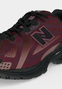 Μαραμπον και μαύρο αθλητικό παπούτσι New Balance με μαύρα κορδόνια, υφή στη σόλα και λεπτομέρεια λογότυπου «N Lock» στο πλάι.