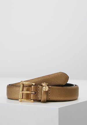 Bruine leren riem met textuur, voorzien van een gouden gesp en een kleine gouden kroonbedel, opgerold tentoongesteld op een witte ondergrond.