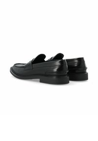 Mocasines de cuero negro con una textura suave, punta redondeada y tacón bajo apilado. Presentan acentos cosidos y una suela plana.