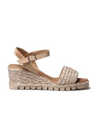 Beige sleehaksandaal met een bovenzijde van geweven jute en enkelbandje. Heeft een gestructureerd oppervlak en een duurzame rubberen zool voor grip.