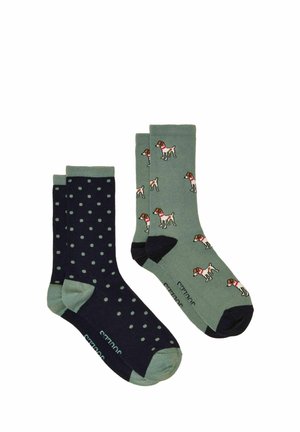 One pair of navy socks with green polka dots and one pair of green socks patterned with small dogs wearing red collars.