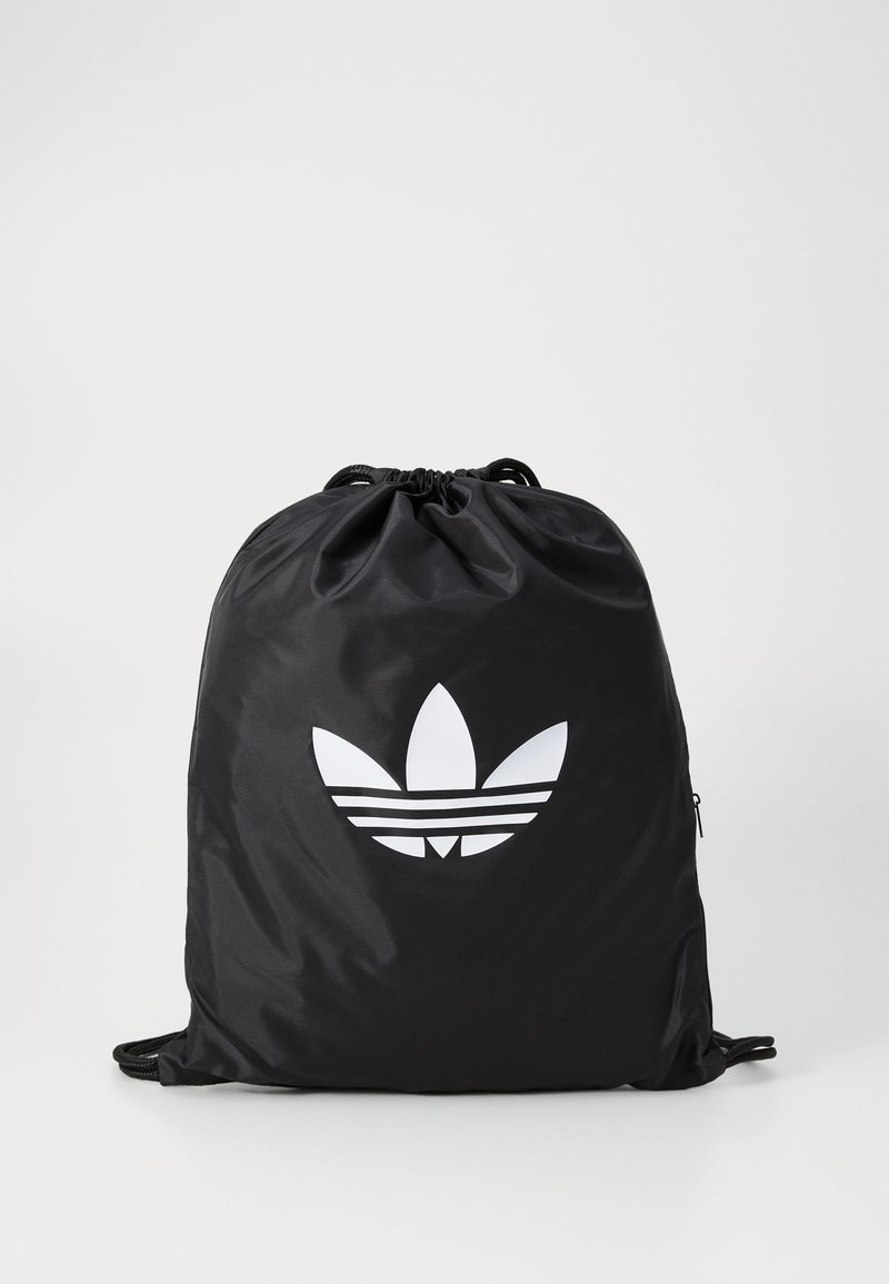 Black drawstring backpack made of nylon, featuring a large white Adidas trefoil logo and adjustable black cords for closure and carrying.