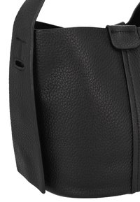 Borsa nera in pelle con superficie testurizzata, forma semi-strutturata, tracolla sottile e chiusura a patta con un accento sottile.