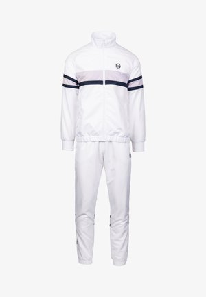 Wit trainingspak gemaakt van glad materiaal, met grijze en marineblauwe horizontale strepen. Beschikt over een hoge kraag, ritssluiting aan de voorkant en elastische manchetten en enkels.