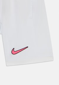 Biele športové šortky vyrobené z ľahkého materiálu. Na dolnej ľavej strane sa nachádza vyšívané logo Nike v ružovej a čiernej farbe.