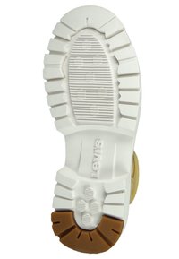 Podeszwa buta z białą gumową częścią dolną z głębokimi rowkami i bruzdami, zaakcentowana brązowym gumowym obcasem. Widoczny logo 'Levi's'.