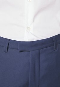 Navy trousers with a smooth texture, featuring a flat front, belt loops, and side pockets. The waistband has a hidden closure.