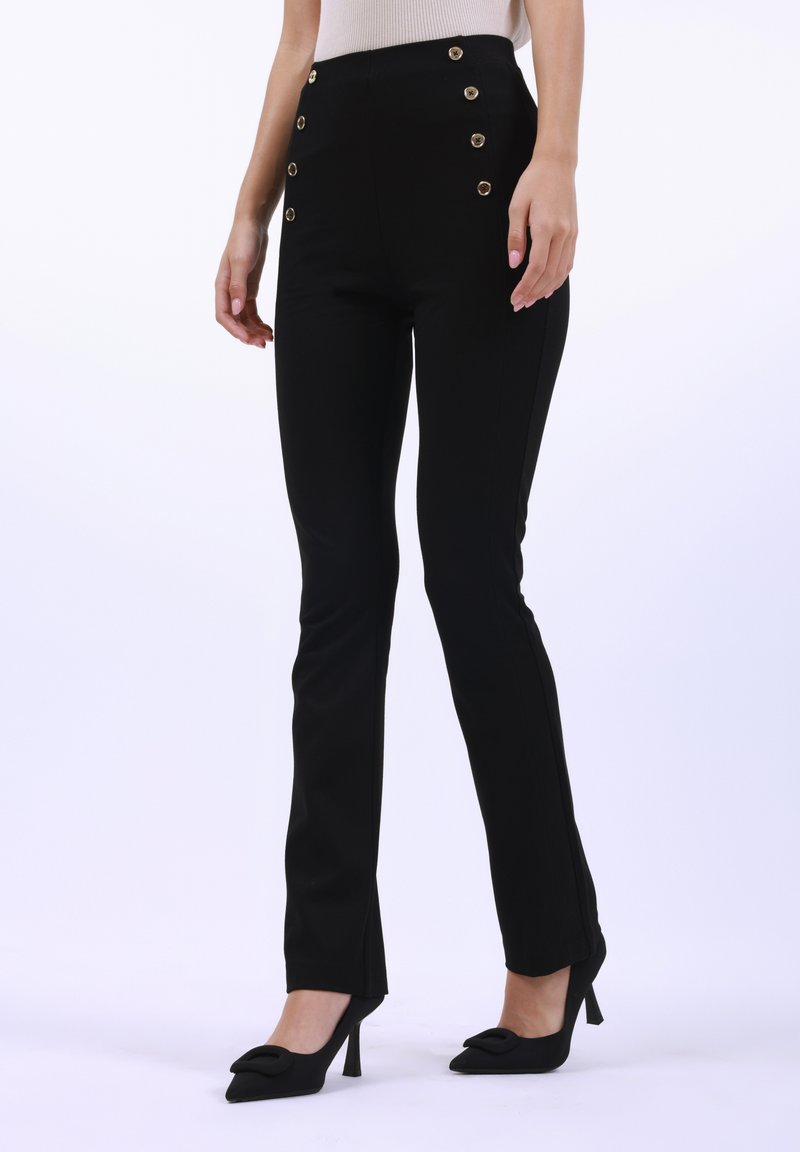 Pantaloni neri a vita alta con dettagli in bottone dorato sui lati. Il tessuto è liscio, con un design slim fit e una leggera svasatura all'orlo.