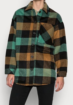 Buttoned oversized flannel shirt with green, brown, black, and beige large check pattern and single chest pocket on left side.