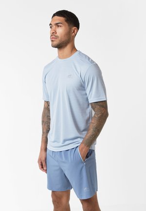 Tricou sportiv de culoare albastru deschis, cu tehnologie de evacuare a umidității, cu mâneci scurte și guler rotund; asociat cu pantaloni scurți de culoare albastru deschis, dotati cu buzunare laterale și logo.