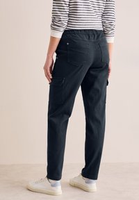 Sorte cargosbukser i bomuld med en afslappet pasform, der har to sidelommer, en elastisk talje og en baglomme.