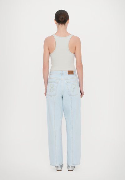 Lyseblå high-waisted jeans med vide ben, med to baklommer med broderte bokstaver "B" og "P," og et brunt lærpatch.