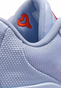 Hellblaue Sneaker aus Mesh-Gewebe mit glänzenden Akzenten. Mit einer orangefarbenen, herzförmigen Stickerei im Knöchelbereich.