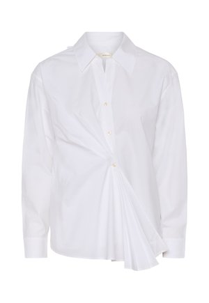 Chemise blanche à manches longues avec col pointu, boutonnière, et un détail plissé asymétrique froncé sur le côté avant droit.