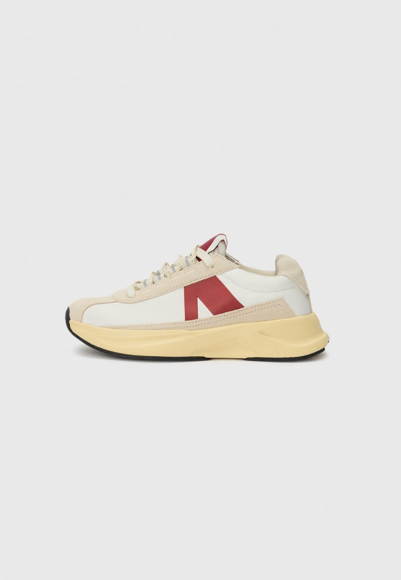 Sneaker with a white mesh upper, beige suede accents, red logo, and yellow midsole. Features flat laces and a textured black outsole.