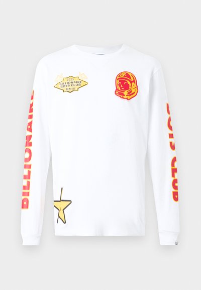 Λευκό μακρυμάνικο t-shirt με κόκκινα γραφικά, που περιλαμβάνουν έναν αστροναύτη και αστέρια. Οι ετικέτες αναγράφουν «Billionaire Boys Club» και «2025».