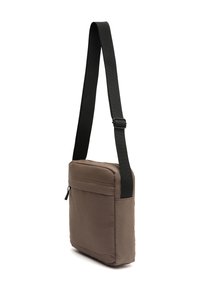 Borsa a spalla in tessuto marrone con una tracolla nera regolabile. Dotata di un compartimento principale con zip e una piccola tasca frontale. Forma rettangolare.