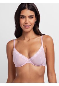 Light pink bra with sheer paneling, scalloped lace trim along the neckline, adjustable straps, and underwire support.