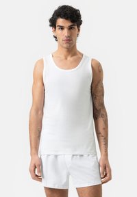 White cotton sleeveless tank top with a round neckline, paired with white cotton shorts, featuring a smooth texture and fitted design.