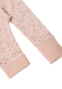 Jasnoróżowe legginsy z rozproszonym czerwonym nadrukiem ptaków, wyposażone w miękkie, teksturowane mankiety i dopasowany krój. Elastyczny pas dla wygody.